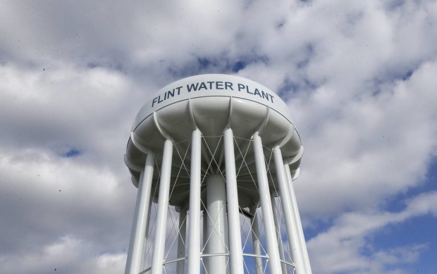 In a March 21, 2016 photo, the Flint Water Plant water tower is seen in Flint, Mich. Flint residents who've grown accustomed to using bottled water and avoiding the faucet are now getting new instructions: Use more tap water. The conundrum is that city residents aren't running enough water to rid the system of toxic lead. People aren't showering as much, are afraid to drink tap water even with faucet filters, and don't want to pay high water bills to run water they're not using. But that's slowing efforts to clean out lead deposits and effectively recoat the pipes and plumbing to make them safe again. (AP Photo/Carlos Osorio)