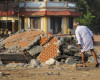 An elderly Indian man checks the damage caused by a massive fire which broke out Sunday during a fireworks display at the Puttingal temple complex in Paravoor village, Kollam district, southern Kerala state, India, Monday, April 11, 2016. Medical teams on Monday tended to hundreds of people injured in a massive fire that killed more than a hundred, while authorities searched for those responsible for illegally putting on the fireworks display that caused the weekend blaze. (AP Photo/Aijaz Rahi)