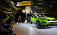 In this photo taken Monday, April 11, 2016, visitors examine the Yuan, BYD's latest Plug-in Hybrid mini SUV introduced at the BYD Dreams Conference in Beijing, China. Industry data released Tuesday, April 12, 2016 show that Chinese auto sales rose by nearly 10 percent last month, led by strong demand for SUVs that more than offset slipping passenger car sales. (AP Photo/Ng Han Guan)