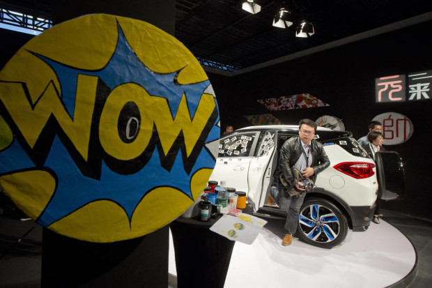 In this photo taken Monday, April 11, 2016, a man climbs out from the Yuan, BYD's latest Plug-in Hybrid mini SUV introduced at the BYD Dreams Conference in Beijing, China. Industry data released Tuesday, April 12, 2016 show that Chinese auto sales rose by nearly 10 percent last month, led by strong demand for SUVs that more than offset slipping passenger car sales. (AP Photo/Ng Han Guan)