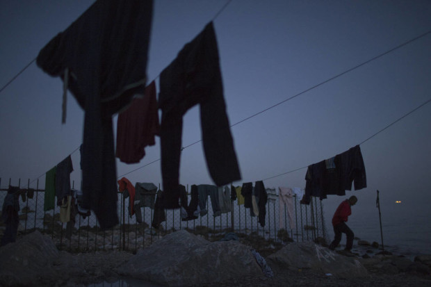 A man walk next clothes hung on a rope to dry in a camp set up by volunteers hosting around 250 migrants near the port of Mytilini, in the Greek island of Lesbos, on Friday, April 15, 2016. Pope Francis will visit the island Saturday joined by Ecumenical Patriarch Bartholomew and the head of the Orthodox Church of Greece, Athens Archbishop Ieronymos II, a mission human rights groups hope will highlight the plight of refugees who fled their war-ravaged homes only to be denied entry to Europe. (AP Photo/Petros Giannakouris)