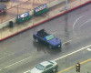 In this image made from video provided by KABC-TV, two burglary suspects being pursued in a convertible Mustang interrupt their flight to spin donuts on a rain-slick street in the Hollywood district of Los Angeles, Thursday, April 7, 2016. The bizarre chase on rainy Southern California streets and highways ended when the pair stopped the car in a South Los Angeles neighborhood, exchanged high-fives with onlookers and took selfies before officers arrived several minutes later and handcuffed them (KABC-TV via AP) MANDATORY CREDIT TV OUT