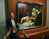 Julie Ducher, French expert specialized in old master paintings, talks to the media in Paris, Tuesday, April 12, 2016 next to a painting that might have been executed by Italian master Caravaggio.  The painting could be worth more than 100 million euros has been found in an attic in Southern France.The picture, whose authenticity has not been established, had been left for more than 150 years in a property in the outskirts of Toulouse. (AP Photo/Michel Euler)