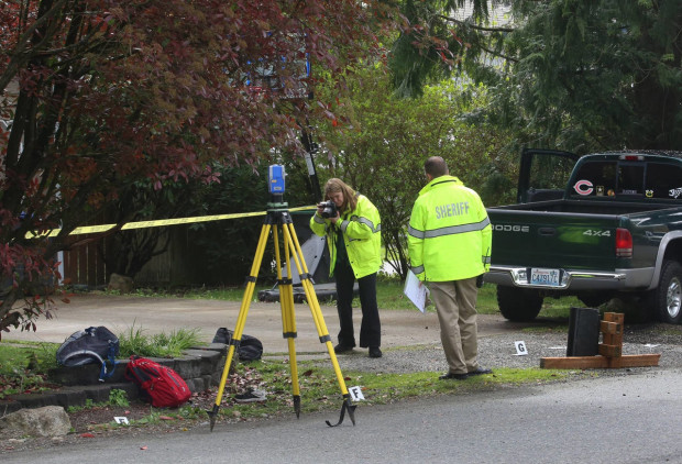 An officer takes a photo at the scene where a pickup truck slammed into children at a school bus stop in Maple Valley, Wash. (Ellen M. Banner/The Seattle Times via AP) SEATTLE OUT; USA TODAY OUT; MAGS OUT; TELEVISION OUT; NO SALES; MANDATORY CREDIT TO BOTH THE SEATTLE TIMES AND THE PHOTOGRAPHER