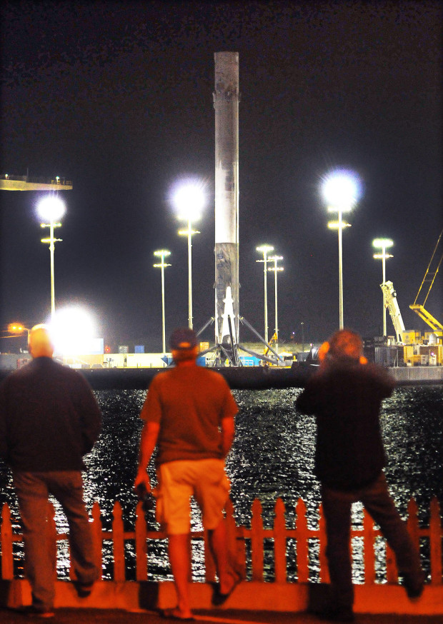People watch as SpaceX Falcon 9 booster returns to Port Canaveral, Fla., early Tuesday, April 12, 2016. (Craig Rubadoux/Florida Today via AP)  NO SALES; MANDATORY CREDIT
