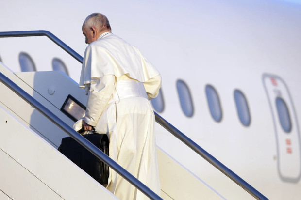 Pope Francis boards an airplane at Rome's Fiumicino airport, Saturday, April 16, 2016, on his way to the Greek island of Lesbos, The Pontiff will visit the island Saturday joined by Ecumenical Patriarch Bartholomew and the head of the Orthodox Church of Greece, Athens Archbishop Ieronymos II, a mission human rights groups hope will highlight the plight of refugees who fled their war-ravaged homes only to be denied entry to Europe. (AP Photo/Gregorio Borgia)