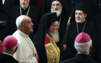 FILE - In this Saturday, Nov. 29, 2014 file photo, Pope Francis, left, arrives with Ecumenical Patriarch Bartholomew I to attend an ecumenical prayer at the Patriarchal Church of St. George in Istanbul. On Saturday, April 16, 2016, Pope Francis heads to Lesbos island along with the spiritual leader of the world’s Orthodox Christians and the head of the Church of Greece to voice their solidarity with the refugees and migrants who have streamed into Europe fleeing war, poverty and persecution for better lives in its prosperous heartland - a trip that could embarrass EU leaders already under fire from human rights groups over the deportations. (AP Photo/Thanassis Stavrakis, File)