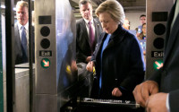 Democratic presidential candidate Hillary Clinton holds her Metrocard as she goes through the turnstile to enter the subway in the Bronx borough of New York, Thursday, April 7, 2016. (AP Photo/Richard Drew)