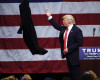 Republican presidential candidate Donald Trump tosses his coat during a rally at Griffiss International Airport in Rome, N.Y.,Tuesday, April 12, 2016. (AP Photo/Mike Groll)