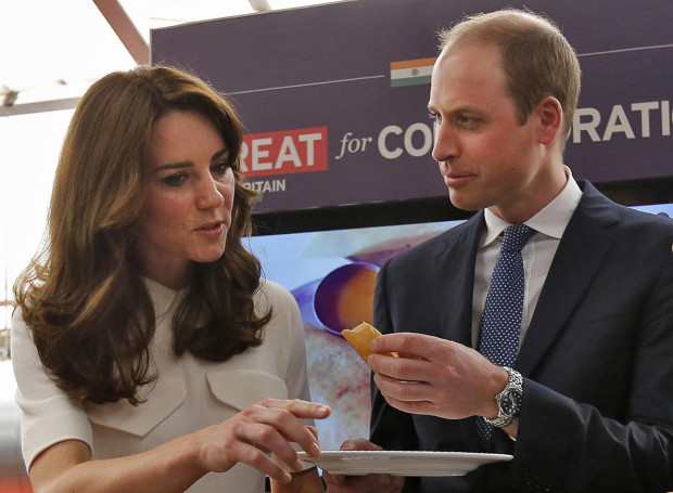 Britain's Prince William eats a "dosa",  or a rice pancake as his wife Kate, the Duchess of Cambridge, watches during an event on young entrepreneurs in Mumbai, India, Monday, April 11, 2016. (Danish Siddiqui/Pool Photo via AP)