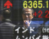 A man is reflected on an electronic board of a securities firm in Tokyo, Friday, April 15 2016. Asian stocks mostly edged lower on Friday as investors assessed a report on Chinese quarterly economic growth while Japanese shares dropped after an earthquake. (AP Photo/Koji Sasahara)