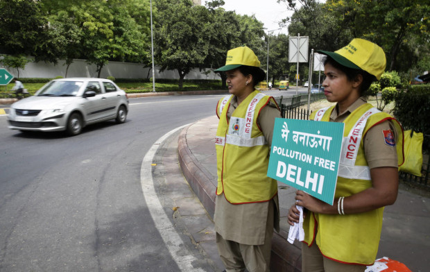 Volunteers remind commuters the reason for restriction placed on vehicle movement in New Delhi, India, Friday, April 15, 2016. The New Delhi government has begun a second round of a two-week car restriction whereby private cars will be allowed on the streets on alternate days from Friday until April 30 based on even or odd license plate numbers, to reduce air pollution that has made the Indian capital the world's most polluted city. (AP Photo/Saurabh Das)