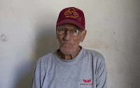 In this April 5, 2016 photo, Pedro Alejandro Lopez, 83, poses for a portrait inside his home on Calle Habana in Old Havana, Cuba. Lopez and his wife moved in their 1918 four-bedroom colonial home on Calle Habana forty years ago. A truck driver from the national electric company, the state let him purchase the home in exchange for monthly payments of 50 pesos over the course of 20 years, the equivalent of about $2 a month, not adjusted for inflation. (AP Photo/Desmond Boylan)