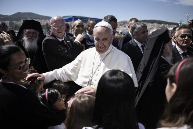 In this photo released by Greek Prime Minister's office on Saturday, April 16, 2016, Pope Francis, greets children at the port of Mytilene, on the Greek island of Lesbos. Pope Francis implored Europe on Saturday to respond to the migrant crisis on its shores "in a way that is worthy of our common humanity," during an emotional and provocative trip to Greece. (Andrea Bonetti/Greek Prime Minister's Office via AP)
