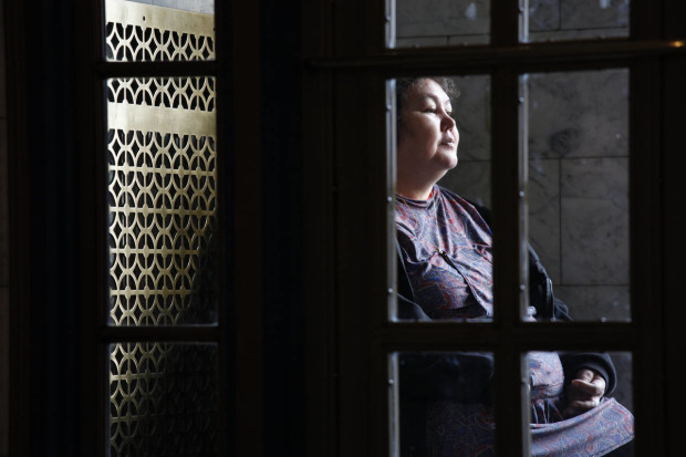 In this Friday, Feb. 5, 2016 photo, Eunice Hadley, of Buckland Alaska, sits on the steps of the Capitol building, wearing an atikluk (also known as a kuspuk) made by her mother, during a trip to lobby legislators for a new school in her remote district in the northwestern part of the state in Juneau, Alaska. Hadley said when she travels to the legislature she appreciates seeing members wearing the traditional Alaska Native garment. (AP Photo/Rashah McChesney)