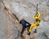 In this photo provided by Bob Isenberg, Michael Banks is stranded on a ledge some 80 feet off the ground on Morro Rock, a landmark in Morro Bay, Calif., Thursday, April 7, 2016. He had scaled the rock to make an Internet proposal to his girlfriend - who said yes - but then got stuck on a ledge and couldn't get down. A helicopter had to be called, and Morro Bay Fire Department Capt. Todd Gailey was lowered by cable to pluck Banks and take him to safety.(Bob Isenberg via AP)