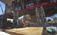 In this Tuesday, March 29, 2016 photo, a construction worker labors to prepare a new foundation for Bruce Guignard's home on Lake Katherine in Columbia, S.C. The house was deluged by flood waters during the historic rains and floods that hit South Carolina last October and is being lifted above flood plain level in Columbia. (AP Photo/Richard Shiro)