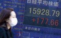 A woman walks past an electronic stock board showing Japan's Nikkei 225 index at a securities firm in Tokyo, Tuesday, April 12, 2016. Asian stock markets mostly gained on Tuesday as investors awaited corporate earnings results at home and abroad. (AP Photo/Eugene Hoshiko)