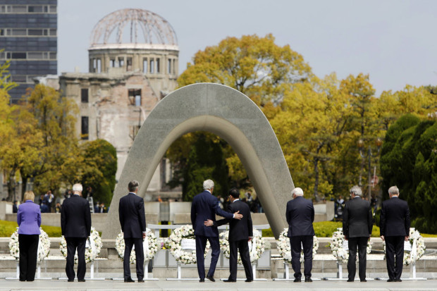 U.S. Secretary of State John Kerry, center left, puts his arm around Japan's Foreign Minister Fumio Kishida, center right, after they and fellow G7 foreign ministers laid wreaths at the cenotaph at Hiroshima Peace Memorial Park in Hiroshima, western Japan Monday, April 11, 2016. Also pictured are, from left to right, E.U. High Representative for Foreign Affairs Federica Mogherini, Canada's Foreign Minister Stephane Dion, Britain's Foreign Minister Philip Hammond, Germany's Foreign Minister Frank-Walter Steinmeier, Italy's Foreign Minister Paolo Gentiloni and France's Foreign Minister Jean-Marc Ayrault.  (Jonathan Ernst/Pool Photo via AP)