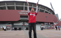 In this Sunday April 10, 2016 photo, Hiroyuki Yokoyama, a 46-year-old supporter of Hiroki Yokoyama, a right-hander for the Hiroshima Toyo Carp, poses for a photo in front of the team’s home stadium as he wished a victory for the team's away game later, in Hiroshima, western Japan. This year’s two-day Group of Seven foreign ministers’ meeting started Sunday. (AP Photo/Mari Yamaguchi)