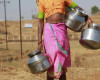 In this Photo taken on April 12, 2016, a woman carries utensils to fetch water from a broken pipe line at Panch Amber village, 140 kilometers (87 miles) north-east of Mumbai, India. Another year of severe drought has left hundreds of millions reeling in at least 13 Indian states, and experts predict the situation will only worsen as summer stretches on. (AP Photo/Rafiq Maqbool)