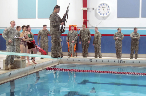In this April 12, 2016 photo, ROTC cadet Friedrich Sala holds a rifle while preparing to jump into the pool at Norwich University in Northfield, Vt. The exercise is part of the training undergone by ROTC students at Norwich. On April 21 and 22 some of the nations top military officers will be at Norwich to commemorate the 100th anniversary of ROTC, which produces about 70 percent of the nations military officers. (AP Photo/Wilson Ring)