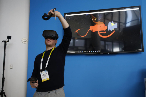 FILE - In this Jan. 6, 2016 file photo, Matthew Taylor paints in 3D virtual reality at the Intel booth using HTC Vive virtual reality goggles at CES International in Las Vegas. (AP Photo/John Locher, File)