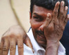 An unidentified man weeps as bodies of victims lie outside a morgue at the Kollam district hospital after a massive fire broke out during a fireworks display at the Puttingal temple complex in Paravoor village, Kollam district, southern Kerala state, India, Sunday, April 10, 2016. Dozens were killed and many more were injured when a spark from an unauthorized fireworks show ignited a separate batch of fireworks that were being stored at the temple complex, officials said.(AP Photo/ Jyothiraj. N.S)