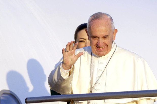 Pope Francis waves to journalists as he boards an airplane at Rome's Fiumicino airport, Saturday, April 16, 2016, on his way to the Greek island of Lesbos, The Pontiff will visit the island Saturday joined by Ecumenical Patriarch Bartholomew and the head of the Orthodox Church of Greece, Athens Archbishop Ieronymos II, a mission human rights groups hope will highlight the plight of refugees who fled their war-ravaged homes only to be denied entry to Europe. (AP Photo/Gregorio Borgia)