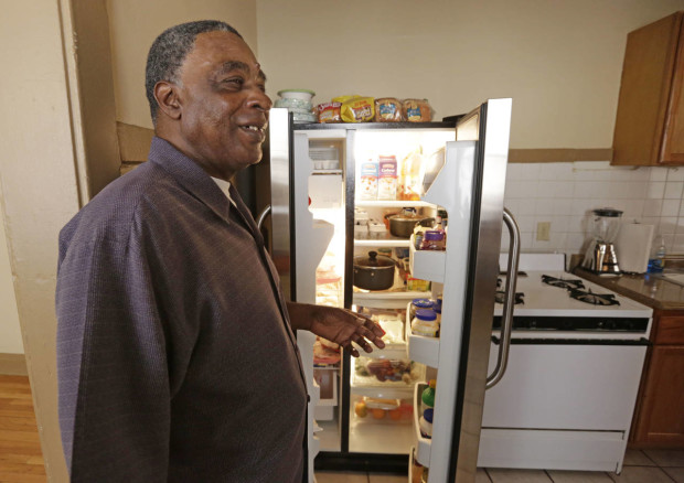 In this March 8, 2016 photo, George Wilson, a resident of a sober home in Chicago, shows off the refrigerator in the apartment he shares with a roommate. Wilson, 76, has lived in the sober home 11 years. He has four children and 12 grandchildren. (AP Photo/M. Spencer Green)