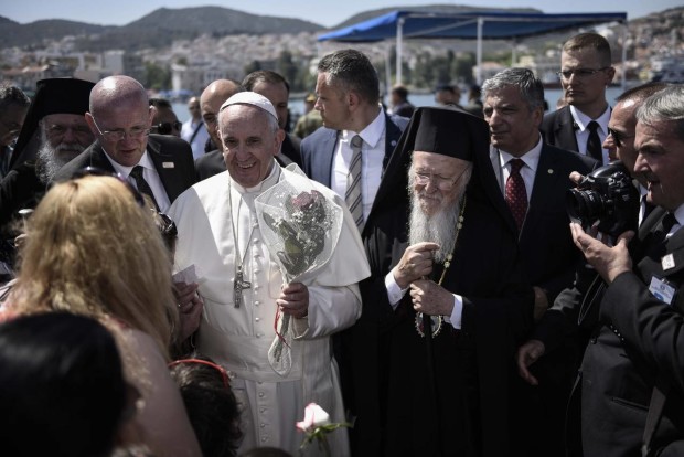 In this photo released by Greek Prime Minister's office on Saturday, April 16, 2016, Pope Francis, left, is escorted by Ecumenical Patriarch Bartholomew I, during a visit on the Greek island of Lesbos. Pope Francis implored Europe on Saturday to respond to the migrant crisis on its shores "in a way that is worthy of our common humanity," during an emotional and provocative trip to Greece.  (Andrea Bonetti/Greek Prime Minister's Office via AP)