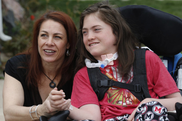 Stacey Linn jokes with her 15-year-old son, Jack, Sunday, April 10, 2016, outside their home in Lakewood, Colo. Jack, who has cerebral palsy, is not allowed to wear a skin patch delivering a cannabis-derived treatment to school. A new Colorado law allowing medical marijuana use at public schools will be looked at by state lawmakers Monday because no school districts are allowing it even though the law says they can. (AP Photo/David Zalubowski)