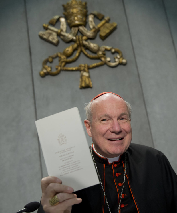 Cardinal Christoph Schoenborn shows a copy of the post-synodal apostolic exhortation ' Amoris Laetitia ' (The Joy of Love) during a press conference at the Vatican, Friday, April 8, 2016. Pope Francis has insisted that individual conscience be the guiding principle for Catholics negotiating the complexities of sex, marriage and family life in a major document released Friday that repudiates the centrality of black and white rules for the faithful. In the 256-page document "The Joy of Love," released Friday, Francis makes no change in church doctrine. (AP Photo/Andrew Medichini)