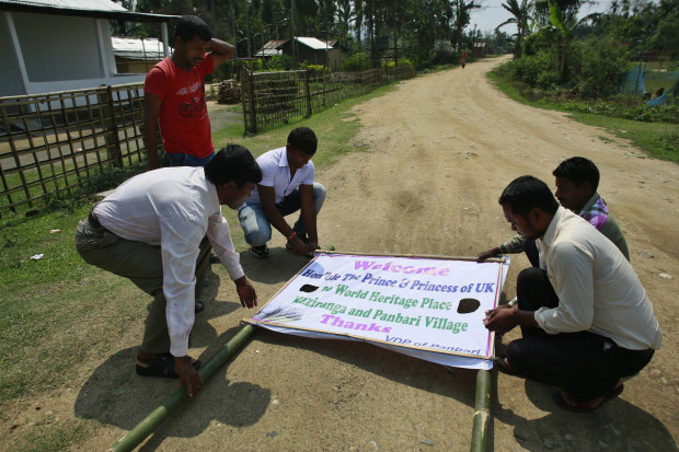 Indian villagers prepare a banner to welcome the Duke and Duchess of Cambridge in Panbari village near  Kaziranga National Park, east of Gauhati, northeastern Assam state, India, Tuesday, April 12, 2016. The British royal couple is visiting the wildlife park specifically to focus global attention on conservation. The 480-square-kilometer (185-square-mile) grassland park is home to the world's largest population of rare, one-horned rhinos as well as other endangered species, including swamp deer and the Hoolock gibbon. (AP Photo/ Anupam Nath)