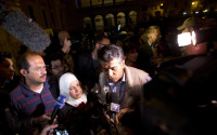 Syrian refugee Wafa, center with white head scarf, and her husband Osama, left, answer reporter's questions with an interpreter as they arrive at the St. Egidio Community in Rome, Saturday, April 16, 2016. Pope Francis flew back with him to Italy from Greece three Muslim families who were in a refugee camp on the island of Lesbos. The Roman Catholic charity Sant'Egidio, which is providing the refugees with preliminary assistance, welcomed them at their headquarters in Rome's Trastevere neighborhood late Saturday. (AP Photo/Alessandra Tarantino)