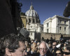Backdropped by St. Peter's Basilica dome, US presidential candidate Bernie Sanders meets reporters outside the Perugino gate at the Vatican, Friday, April 15, 2016. Sanders spoke at a conference commemorating the 25th anniversary of "Centesimus Annus," a high-level teaching document by Pope John Paul II on the economy and social justice at the end of the Cold War. (Angelo Carconi/ANSA via AP)