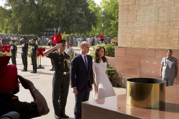 Britain's Prince William, along with his wife Kate, the Duchess of Cambridge, centre, pay their tributes at the India Gate war memorial, in the memory of the soldiers from Indian regiments who served in World War I, in New Delhi, India, Monday, April 11, 2016. (Manish Swarup/Pool Photo via AP)