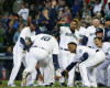 Seattle Mariners' Dae-Ho Lee (10) is greeted at the plate by teammates after he hit a walk-off two-run home run in the tenth inning of a baseball game against the Texas Rangers, Wednesday, April 13, 2016, in Seattle. The Mariners beat the Rangers 4-2 in ten innings. (AP Photo/Ted S. Warren)