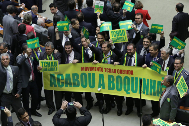 Opposition lawmakers hold a sign that reads in Portuguese "Goodbye dear movement. It's over" during a debate on whether or not to impeachment President Dilma Rousseff in the Chamber of Deputies in Brasilia, Brazil, Friday, April 15, 2016. The lower chamber of Brazil's Congress began the debate on whether to impeach Rousseff, a question that underscores deep polarization in Latin America's largest country and most powerful economy.  The crucial vote is slated for Sunday. (AP Photo/Eraldo Peres)