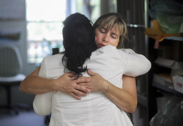 Nina Blakeman, right, of the Palm Beach Zoo receives a hug inside the zoo office after zookeeper Stacey Konwiser, Friday, April 15, 2016 in West Palm Beach, Fla. Stacey Konwiser, 38, was attacked and killed by a 13-year-old male tiger in an enclosure known as the night house that is not visible to the public, Palm Beach Zoo spokeswoman Naki Carter said. It's where the tigers sleep and are fed. (Damon Higgins/Palm Beach Post via AP)  MAGS OUT; TV OUT; NO SALES; MANDATORY CREDIT