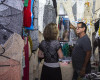 In this April 4, 2016 photo, salesman Victor Rodriguez helps a customer at his stall in the Almacenes San Jose in Havana, Cuba. Rodriguez imagines a future Cuban economy where he can import large quantities of thread, export his women’s clothing to other countries and not have to worry about obtuse state regulations governing everything down to where exactly he can place items at his small retail stand. (AP Photo/Desmond Boylan)