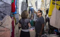 In this April 4, 2016 photo, salesman Victor Rodriguez helps a customer at his stall in the Almacenes San Jose in Havana, Cuba. Rodriguez imagines a future Cuban economy where he can import large quantities of thread, export his women’s clothing to other countries and not have to worry about obtuse state regulations governing everything down to where exactly he can place items at his small retail stand. (AP Photo/Desmond Boylan)