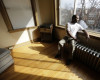 In this March 8, 2016 photo, Darnell Johnson, 50, a resident of a sober home in Chicago, looks out the window of his apartment. Johnson says he was a "weekend social drinker, but it would last all day." Now when he smells alcohol or sees how it affects others, he remembers the bad times. (AP Photo/M. Spencer Green)