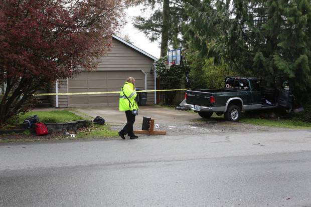 An officer walks near the scene where a pickup truck slammed into children at a school bus stop in Maple Valley, Wash. (Ellen M. Banner/The Seattle Times via AP) SEATTLE OUT; USA TODAY OUT; MAGS OUT; TELEVISION OUT; NO SALES; MANDATORY CREDIT TO BOTH THE SEATTLE TIMES AND THE PHOTOGRAPHER