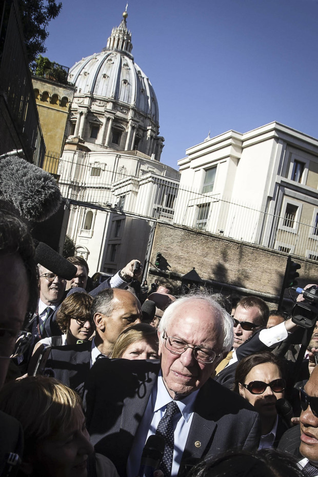 Backdropped by St. Peter's Basilica dome, US presidential candidate Bernie Sanders meets reporters outside the Perugino gate at the Vatican, Friday, April 15, 2016. Sanders spoke at a conference commemorating the 25th anniversary of "Centesimus Annus," a high-level teaching document by Pope John Paul II on the economy and social justice at the end of the Cold War. (Angelo Carconi/ANSA via AP)