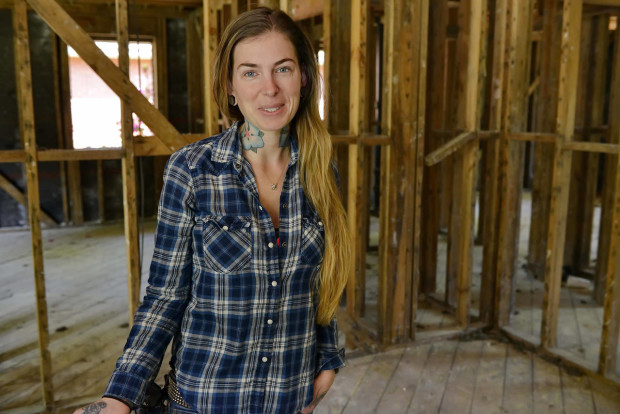 In this Tuesday, March 29, 2016 photo, resident-turned-activist Rachel Larratt stands inside one of the damaged homes in her neighborhood near Gills Creek, where many ranch-style, single level homes were flooded or submerged to their rooftops, in Columbia, S.C. After the historic rains and floods battered South Carolina in October, Larratt founded a nonprofit foundation to help people manage the process of seeking assistance to relocate, and selling or repairing damaged homes. (AP Photo/Richard Shiro)