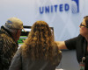 A United Airlines representative, right, helps stranded travelers at Denver International Airport as a severe spring storm packing high winds and heavy, wet snow sweeps over the intermountain West forcing the cancellation of hundreds of flights, Saturday, April 16, 2016, in Denver. (AP Photo/David Zalubowski)