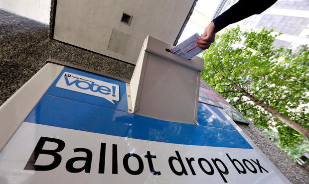 A voter delivers their ballot to a drop box. (AP)...