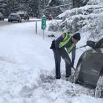 Troopers help a driver out after they crashed in the snow on SR3. (Washington State Patrol)