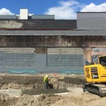 Work is already underway to build a six-story building where the Broadway Post Office once stood.  Until then, ghost signs from an old automotive business are visible. (Feliks Banel/KIRO Radio)